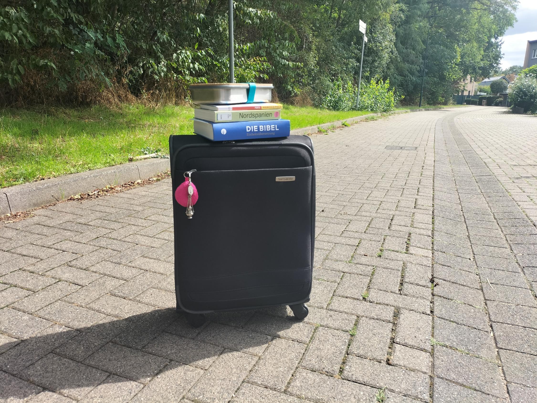 Koffer, Bibel, Reiseführer und Brotdose stehen bereit