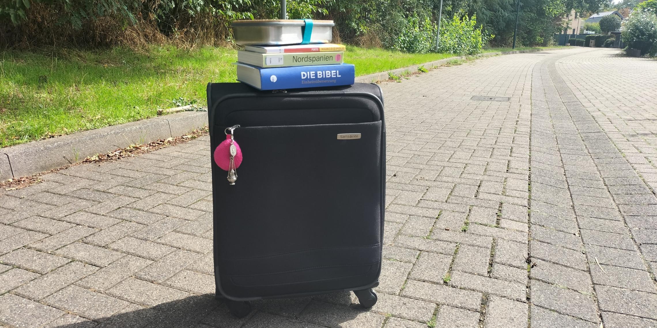 Koffer, Bibel, Reiseführer und Brotdose stehen bereit